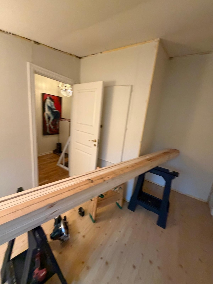 Før: rom med umalte vegger, ubehandlet furugulv og materialer på bukker
